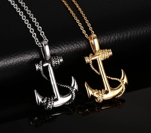 Close-up of anchor pendants in gold and silver finish with matching steel chains