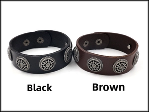 Close-up of black and brown wide leather bracelets with vintage floral metal studs