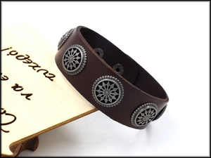 Close-up of brown leather bracelet with round metal rivets on a white background