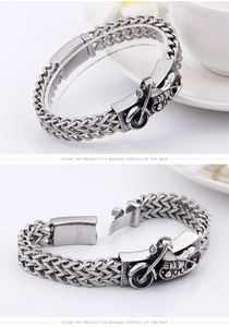 Macro detail of men's stainless steel bracelet featuring 3D motorcycle relief and links
