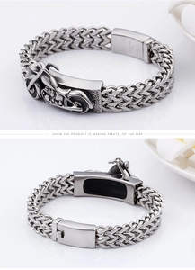 Detailed macro view of retro silver motorcycle relief and clasp on mens steel bracelet