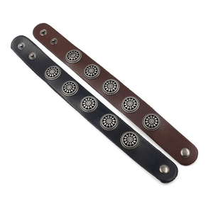 Black and brown leather rivet bracelets with star studs on a clean white background
