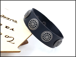 Detailed macro shot of black leather cuff bracelet with vintage silver star metal studs