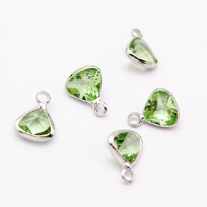 Close-up of olive green triangular crystal pendants with silver metal loops for DIY jewelry