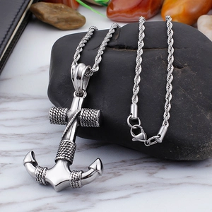 Fashionable anchor pendant necklace in silver stainless steel on dark stone background