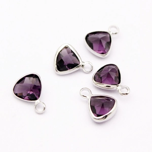 Detailed close-up of five triangular faceted purple crystal pendants with silver metal frames
