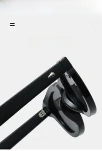 Close-up of black oval sunglasses frame featuring silver metal stud details and hinges