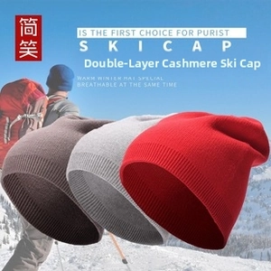 Close-up of double-layered cashmere knit ski hats in brown, grey, and red for winter