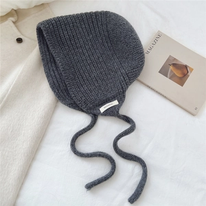 Détail de la texture en tricot 100% laine et de l'étiquette sur le bonnet gris foncé