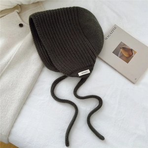 Détail de la cagoule en tricot 100% laine vert olive avec texture épaisse vert olive avec attaches