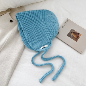 Détail du bonnet en laine bleu clair avec protège-oreilles et texture en maille côtelée