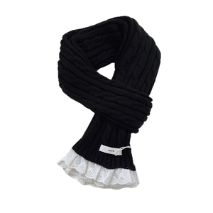 Black knit scarf with cable pattern and white lace trim shown on white background