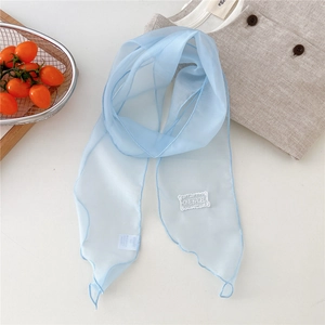 Detail of light blue organza scarf with wave edges and white 'ONE BAGEL' embroidery