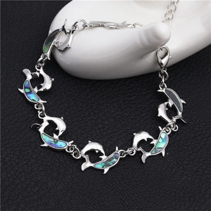 Colorful abalone shell dolphin bracelet in silver finish on a display hand