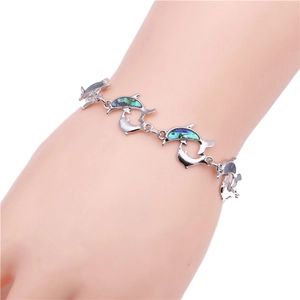 Detail of silver dolphin bracelet with colorful abalone shell inlay on female wrist