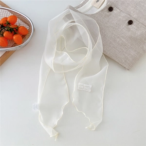 Detail of white semi-transparent scarf with embroidered patch and delicate rolled edges