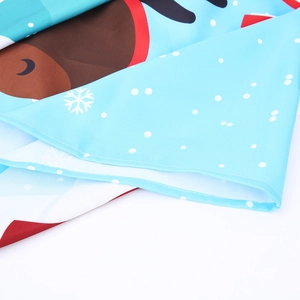 Close-up of Christmas tablecloth showing reindeer prints, snowflakes, and stitched edges