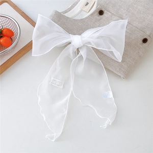 Close-up of white embroidered label on sheer lightweight chiffon bow scarf for women