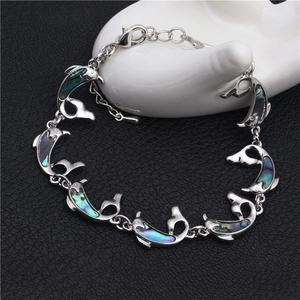 Silver dolphin bracelet featuring colorful abalone shell inlays on a white jewelry stand