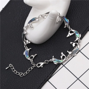 Detailed shot of dolphin-shaped link bracelet with iridescent abalone shell inlays