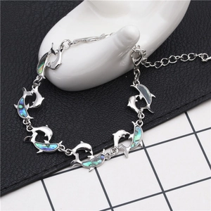 Close-up of silver dolphin bracelet with colorful abalone shell inlays on white model