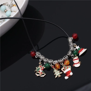 Macro shot of Christmas necklace with silver bell, tree, and snowman pendants on black cord