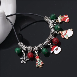 Christmas beaded bracelet with Santa and snowman charms on a black reflective background