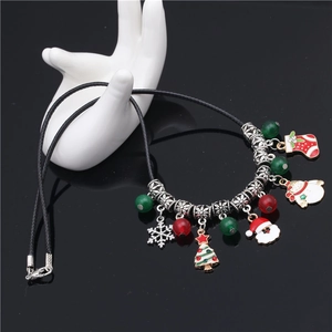 Detailed macro view of colorful Christmas charms on a black braided cord necklace