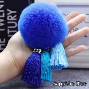 Gedetailleerd beeld van een koningsblauwe bonten pompon hanger met kwastjes