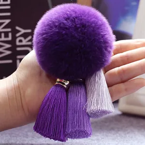 Detail van een paarse bonten pompon sleutelhanger met drie gradiënt kwastjes voor tassen