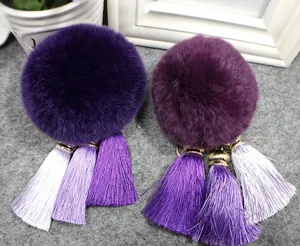 Detail van paarse kunstbont pompon sleutelhangers met elegante meerkleurige zijden kwastjes