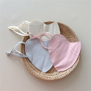 Detail view of breathable sun protection masks in beige, blue, and pink on a tray