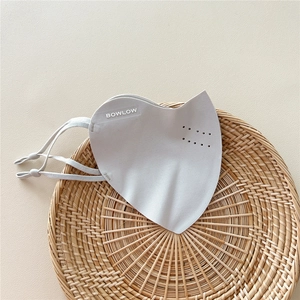 Detail of light grey breathable sun mask with adjustable ear loops on a woven tray