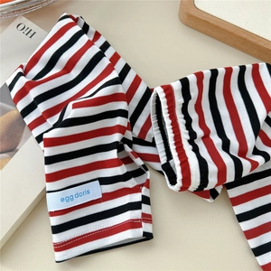 Detailed close-up of striped sun protection arm sleeves with a woven brand label