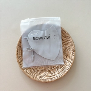 Detail of grey breathable sun mask with adjustable ear loops in minimalist packaging