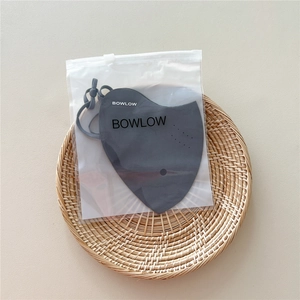 Dark grey heart-shaped sun mask with adjustable ear loops in frosted packaging