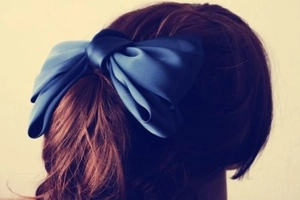 Große marineblaue Satin-Schleife Haarspange an einem braunen Pferdeschwanz Frisur