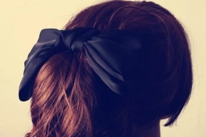 Makroaufnahme der übergroßen schwarzen Satin-Schleife am Hinterkopf für Frauen