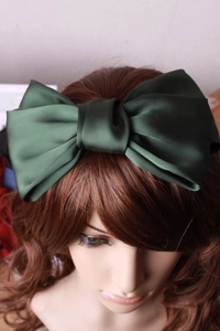 Nahaufnahme einer dunkelgrünen Satin-Haarspange mit großer Schleife am Modell