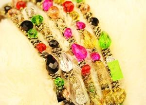 Macro shot of colorful crystal beads on gold woven metal hairbands in various colors
