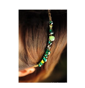 Detail of green crystal beads and gold metal chain on a stylish headband for women