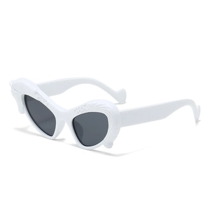 White heart-shaped sunglasses with vintage scalloped edges and dark lenses seen from 45-degree angle