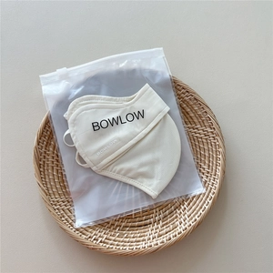 Detail view of the breathable beige sun protection mask with its frosted zip-lock packaging