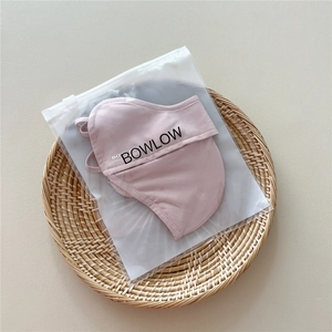 Close-up of pink breathable sun protection mask with ear loops in a matte zipper bag