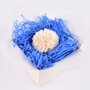 Scatola regalo bianca con carta raffia blu e una decorazione floreale color crema