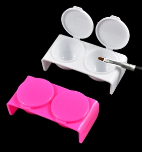 Detailed view of dual-hole plastic nail art glue containers with rose and white flip lids