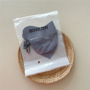 Detail of grey-blue breathable sun mask with adjustable ear loops in brand packaging