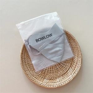 Light gray breathable sun mask with adjustable ear loops and branded storage bag on tray