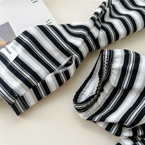 Close-up of striped sun protection arm sleeves with thumb holes and knit texture