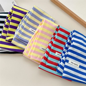 Macro shot of colorful striped knit sun sleeves with woven logo labels and soft texture